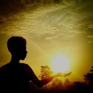 Silhouette person with horse against sky during sunset