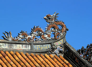 Low angle view of statue against blue sky