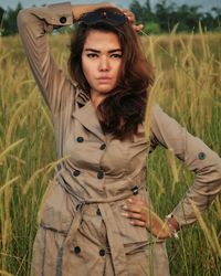 Portrait of young woman standing on field