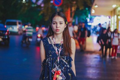 Portrait of young woman standing at night