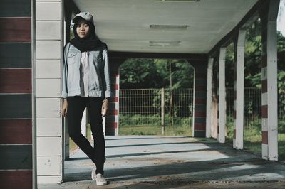 Portrait of woman standing against brick wall