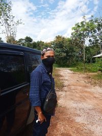 Man standing on street against sky