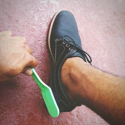 Cropped image of hand brushing shoes