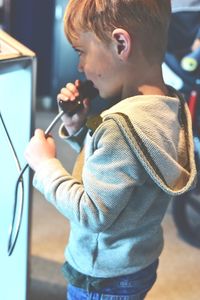 Cute boy talking on telephone at home