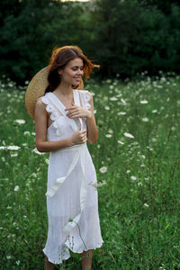 Portrait of smiling young woman standing against plants