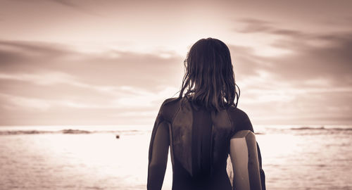 Rear view of girl against sea and sky