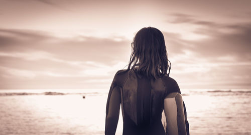 Rear view of woman looking at sea against sky