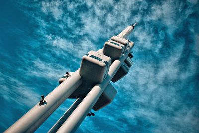 Low angle view of telephone pole by sea against sky