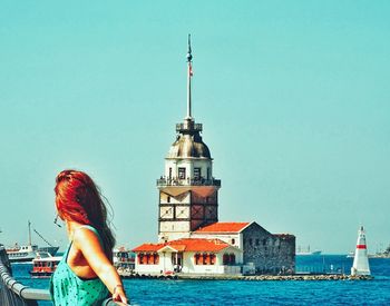 Low angle view of woman by building against sky