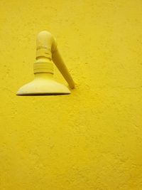 Low angle view of yellow light mounted on wall