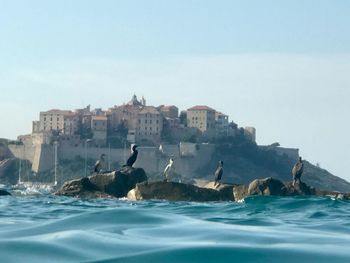 View of city by sea against clear sky