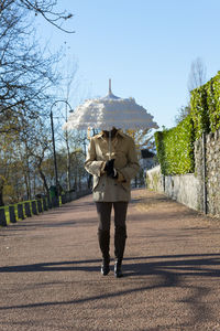 Rear view of woman walking on road