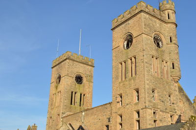 Low angle view of bell tower against blue sky