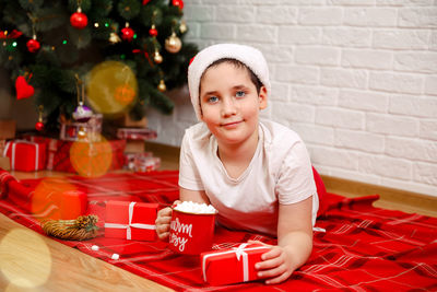 Cute little boy drinking hot chocolate at home on christmas eve.