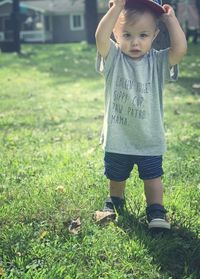 Portrait of boy standing on grassy lawn