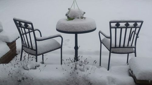 Close-up of chairs on table during winter