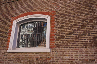 Low angle view of window on brick wall