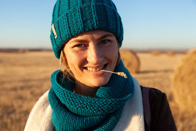 Portrait of a beautiful young model in knitted hat and warm clothes enjoy day, on background field 