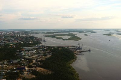 High angle view of townscape by sea against sky