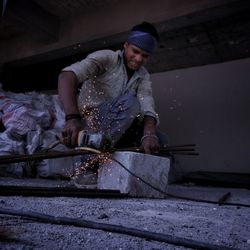 Worker drilling metal at workshop