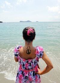 Rear view of woman standing against sea