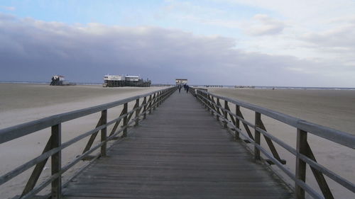 Boardwalk on beach against sky