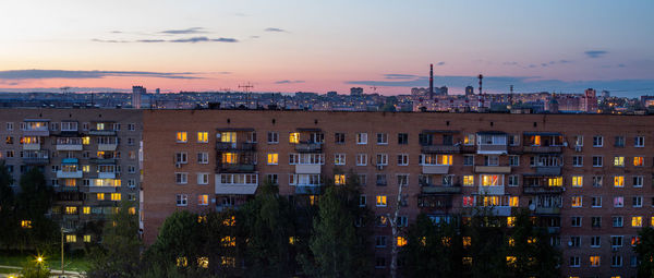 Windows, roofs and facade of an mass apartment buildings in russia at evening