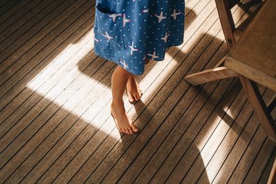 Low section of woman standing on wooden floor