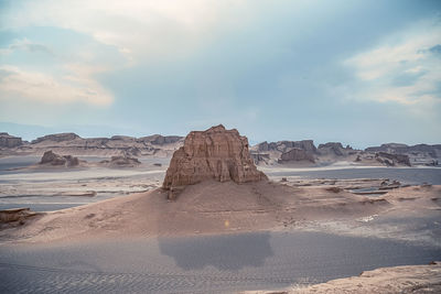 Rock formations on shore against sky