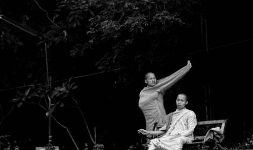 People sitting on branch against trees