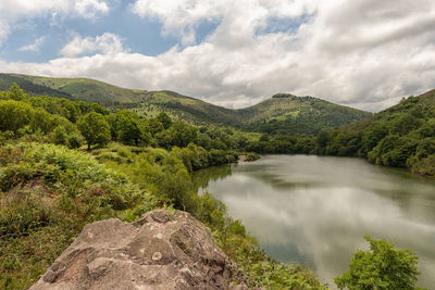 Scenic view of river amidst mountains against sky