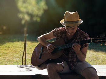 Young man playing guitar in park