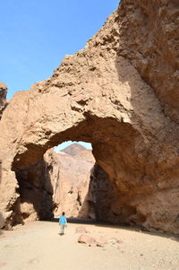 Rear view of man on cliff against clear sky