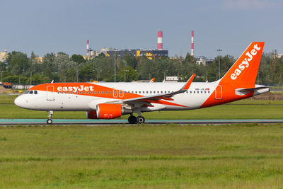 Airplane on airport runway against sky