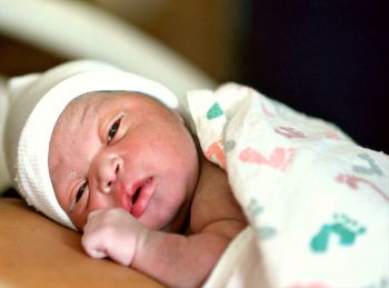 Portrait of cute baby lying on bed