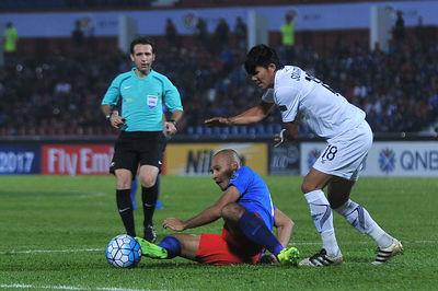 Men playing soccer on field