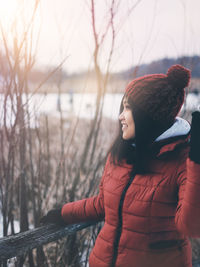 Side view of young woman looking down in winter