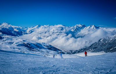 Scenic view of snowcapped mountains against blue sky