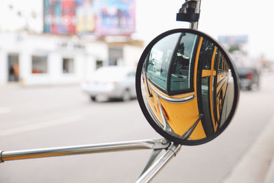 School bus reflecting on side view mirror of bicycle