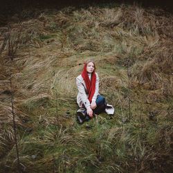 Woman sitting on the river in a red scarf