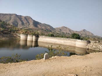 Scenic view of dam and lake against clear sky