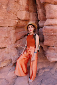 Portrait of a smiling young woman standing on rock