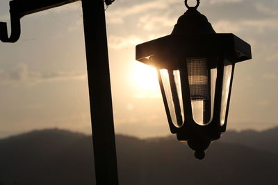 Close-up of electric lamp against sky