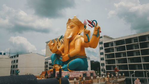 Low angle view of statue against building against sky