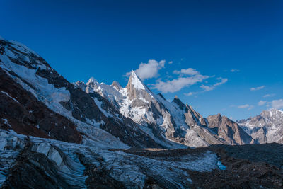 Scenic view of snowcapped mountains against blue sky