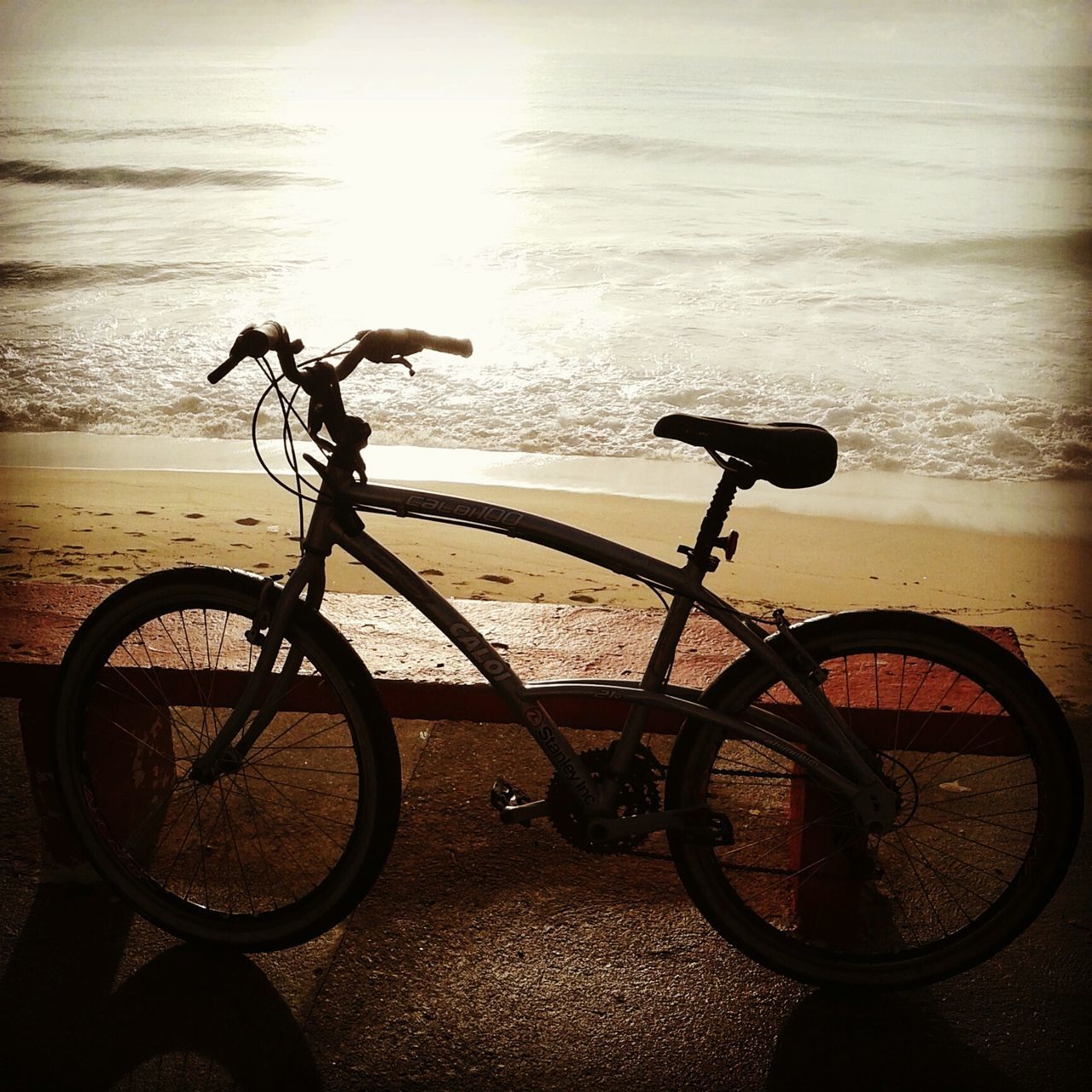 bicycle, transportation, mode of transport, land vehicle, parking, stationary, parked, water, sea, tranquility, horizon over water, nature, sunlight, no people, shadow, outdoors, beauty in nature, cycle, day, beach