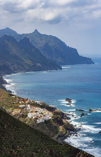 Scenic view of sea and mountains against sky