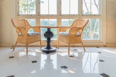 Empty chairs and table against window at home