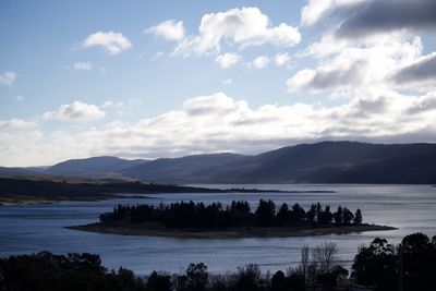 Scenic view of lake by mountains against sky