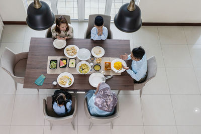 High angle view of people sitting on table